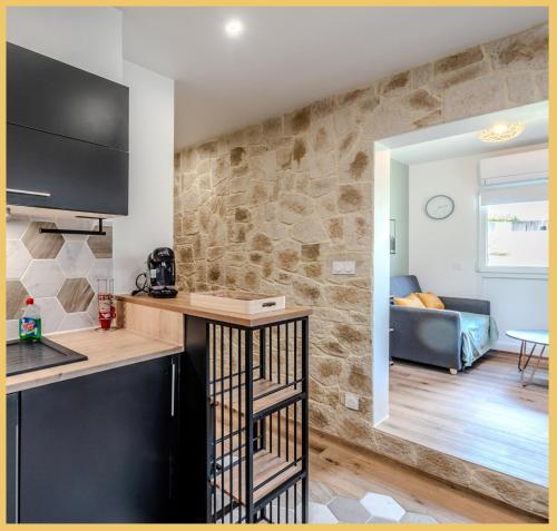 Il comprend une cuisine et un salon avec un mur en pierre. dans l'établissement La petite maison de la plage I Excenevex, à Excenevex