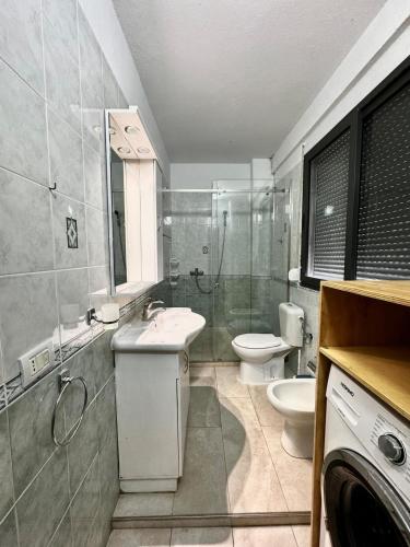 a bathroom with a sink and a shower and a toilet at Large apartment in Golem in Golem