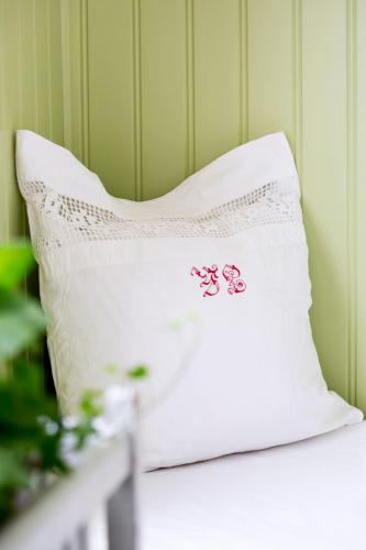 a white pillow with hello kitty embroidery on it at Strandvillan Hotell och Bed & Breakfast in Lysekil