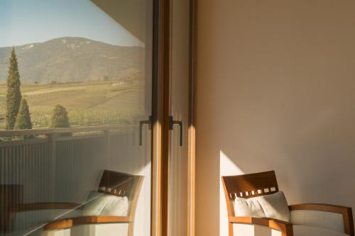 two chairs sitting next to a window with a view at Appartement KroneLiving in Tirolo