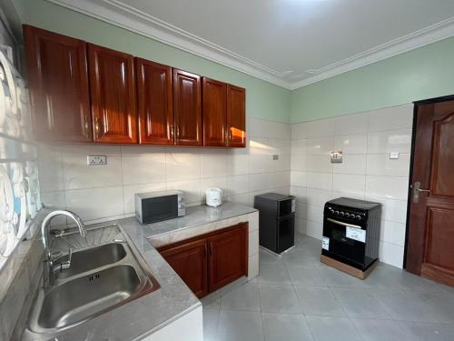a kitchen with a sink and a stove at Biira Transit Residence Entebbe with free airport pickup in Entebbe