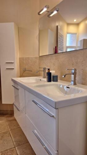 une salle de bain avec un lavabo blanc et un miroir dans l'établissement Spacieux et lumineux 2 chambres terrasse, au Cannet