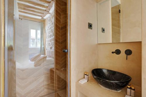 La salle de bains est pourvue d'un lavabo noir et d'une douche. dans l'établissement Spacious apartment - 4BR-10P - Place des Vosges, à Paris