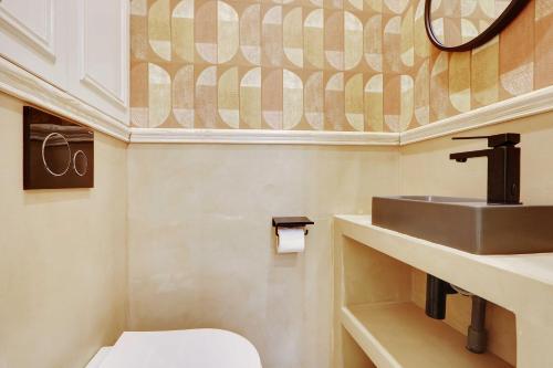 une salle de bain avec un lavabo et des toilettes dans l'établissement Authentic apartment - 1BR-4P - Le Marais, à Paris