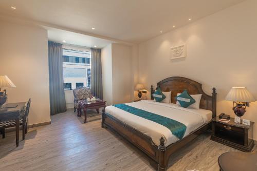 a hotel room with a bed and a desk and a window at Clarks Resort The Archi`s Castle, Ajmer in Ajmer