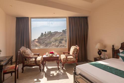 a hotel room with a table and chairs and a window at Clarks Resort The Archi`s Castle, Ajmer in Ajmer