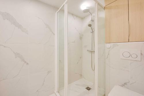 une salle de bain avec une douche avec une porte vitrée dans l'établissement Beautiful Apt -1BR-4P- Tour Eiffel - Invalides, à Paris