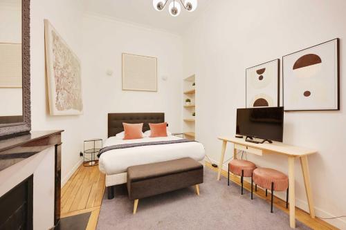une chambre avec un lit, un bureau et une télévision dans l'établissement Beautiful Apt -1BR-4P- Tour Eiffel - Invalides, à Paris