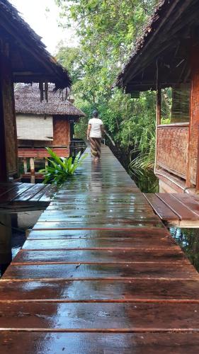 a man walking down a wooden walkway at Mutiara Beach Resort in Berakit