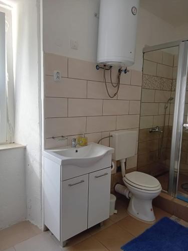a bathroom with a white sink and a toilet at Nerezine centrum _ apartmán pro 2 osoby in Nerezine
