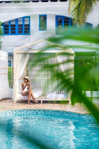 a woman sitting in a gazebo next to a pool at Soul Vacation Resort and Spa,Colva in Colva