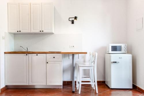 a kitchen with white cabinets and a white refrigerator at Seaside apartments Petar in Krk