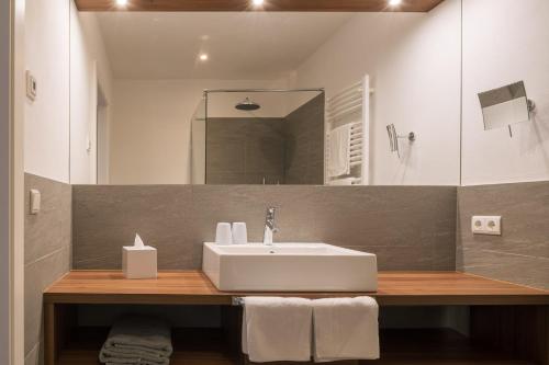 a bathroom with a sink and a mirror at Appartement KroneLiving in Tirolo