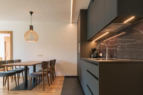 a kitchen with a table and a dining room at Appartement KroneLiving in Tirolo