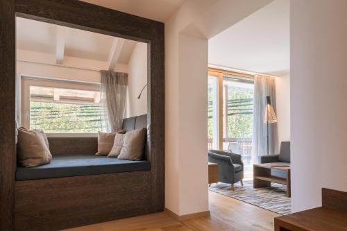 a mirror reflecting a living room with a couch in a room at Appartement KroneLiving in Tirolo
