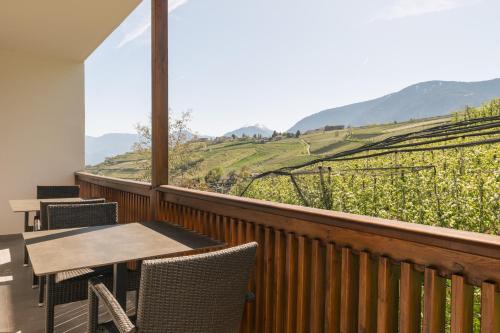 a balcony with a table and chairs and a view at Appartement KroneLiving in Tirolo