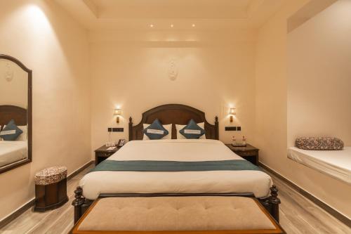 a bedroom with a large bed and a mirror at Clarks Resort The Archi`s Castle, Ajmer in Ajmer
