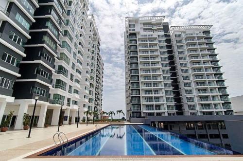 two tall buildings with a swimming pool in front of them at Countryside Condo @One Residence Sekinchan in Sekincan