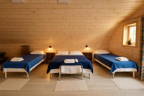 a bedroom with two beds in a wooden room at Apartamentai in Veisiejai