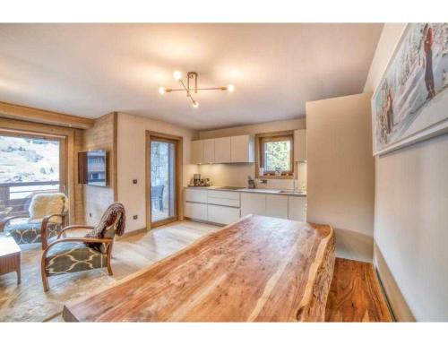 a kitchen with a wooden table in a room at Luxurious 4-room with pool, gym, spa and parking in Megève
