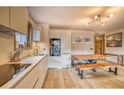 a kitchen with a wooden table and a dining room at Luxurious 4-room with pool, gym, spa and parking in Megève