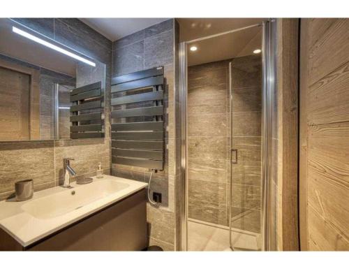 a bathroom with a sink and a glass shower at Luxurious 4-room with pool, gym, spa and parking in Megève