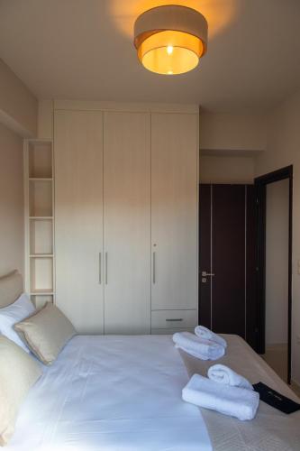 a bedroom with a white bed with towels on it at Ikosapartments -home 3-4 in Perdika