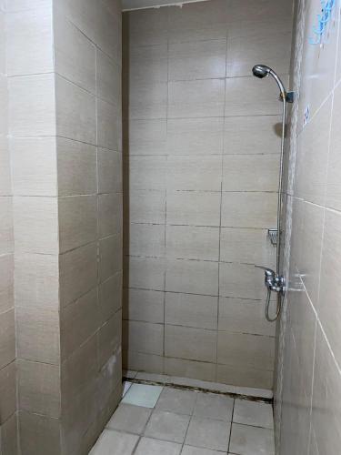 a bathroom with a shower with a tiled floor at deKOST Madiun in Madiun
