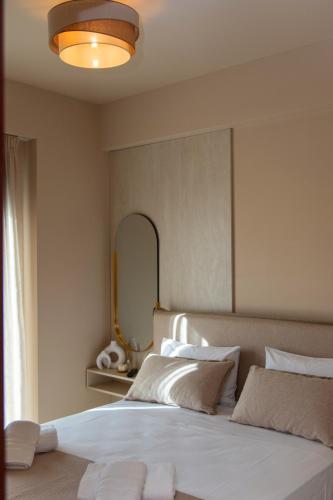 a bedroom with a large white bed with a mirror at Ikosapartments -home 3-4 in Perdika