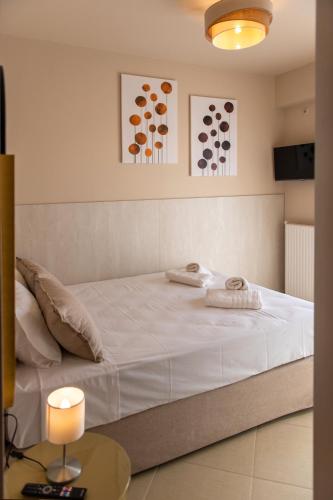 a bedroom with a large white bed and a table at Ikosapartments -home 3-4 in Perdika