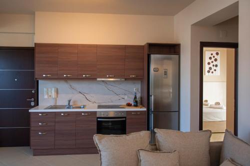a kitchen with wooden cabinets and a stainless steel refrigerator at Ikosapartments -home 3-4 in Perdika