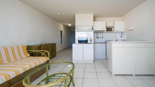 un salon avec un canapé et une cuisine dans l'établissement Les Roches Marines - La Sedna - 2P4, au Cap d'Agde