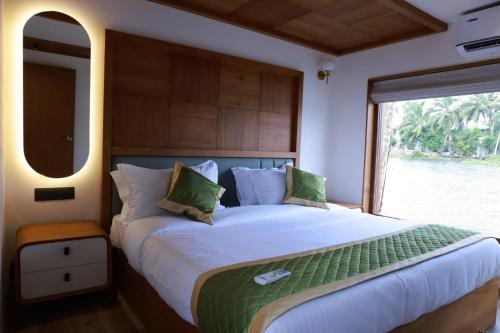 a bedroom with a large bed with a large window at Island of Peace Houseboat in Champakulam