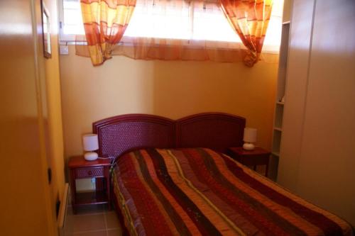 une chambre avec un lit et une fenêtre dans l'établissement Appartement 230, Port Ambonne au village naturiste, au Cap d'Agde