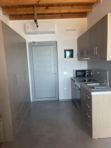 a kitchen with a door leading to a garage at Michalis-Nina studios in Livanianá