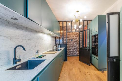 une cuisine avec un évier et un plan de travail dans l'établissement L'élégance - VintageWi-FiCentre, à Angers