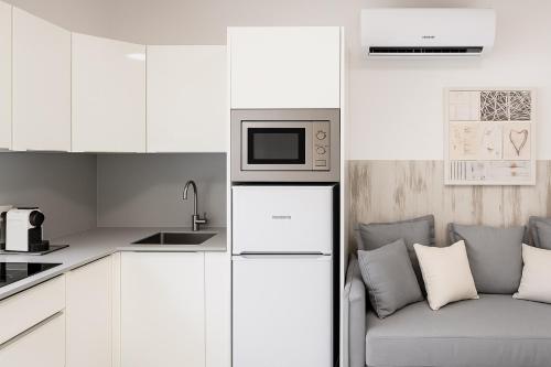 une cuisine blanche avec un canapé et un micro-ondes dans l'établissement Maspalomas Green Club, à Maspalomas