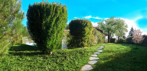 un jardin avec deux arbres et un chemin en pierre dans l'établissement Grande Maison Familiale Premium Super Calme - Piscine - Jacuzzi - Salle de Jeux - Idéalement Située - Gd Jardin Sans aucun vis à vis, à Sauzet