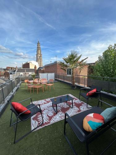 un patio avec une table et des chaises sur un toit dans l'établissement Le Perchoir Arras, à Arras