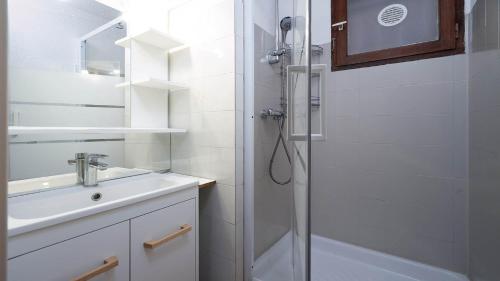 une salle de bain blanche avec une douche et un lavabo dans l'établissement Aloa N113 - 2P6, au Cap d'Agde