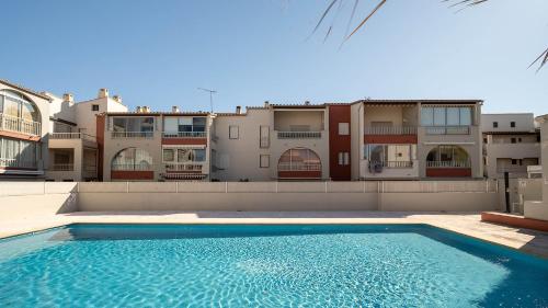 une piscine devant certains immeubles d'habitation dans l'établissement Aloa N113 - 2P6, au Cap d'Agde