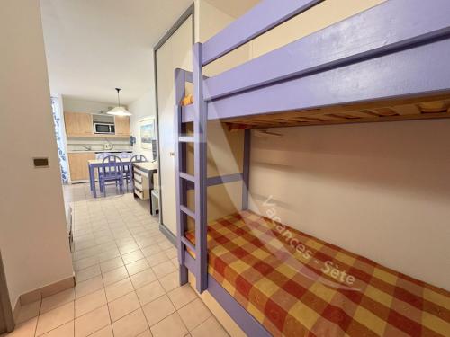 Ce lit superposé se trouve dans un dortoir doté d'une cuisine. dans l'établissement STUDIO VUE MER AVEC PKG, PISCINE, TENNIS, PLAGE DIRECT, à Sète