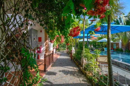 a walkway next to a pool at a resort at Ancient Garden Boutique Hoi An in Hoi An