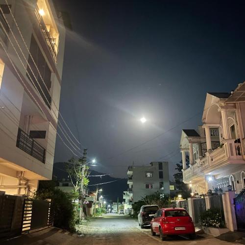 Una calle de la ciudad por la noche con una luna en el cielo en Peaceful Nest Home Stay, en Rājpur