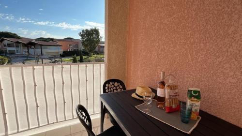 - une table avec des bouteilles et des verres sur un balcon dans l'établissement Isles Évasion-parking-100M plages-commerces, à La Londe-les-Maures