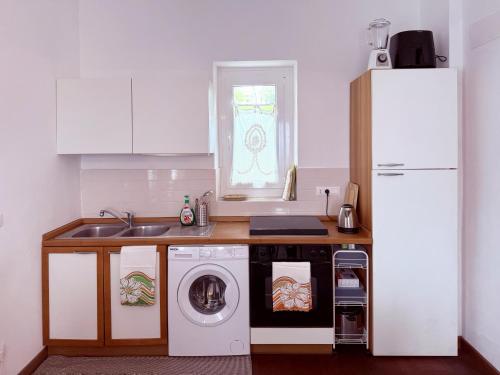 a kitchen with a sink and a washing machine at Casa Mariuccia in Ponzone