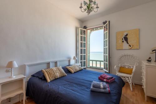 une chambre avec un lit bleu et une fenêtre dans l'établissement La Falaise - Magnifique Vue Mer, à Mers-les-Bains