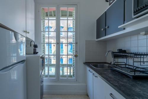 une cuisine avec un réfrigérateur blanc et un évier dans l'établissement La Falaise - Magnifique Vue Mer, à Mers-les-Bains