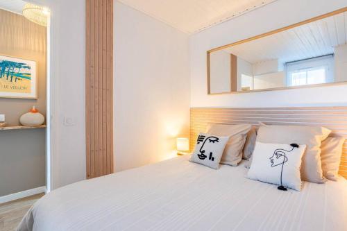 a bedroom with a white bed with a mirror at La Terrasse du Golf in Talmont