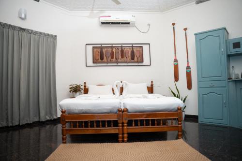 a bedroom with a bed and a blue cabinet at Paddle Cult Surf & Yoga in Varkala